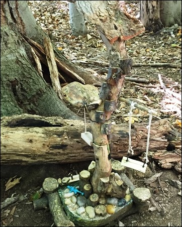 fairy house on a short pole with a swing